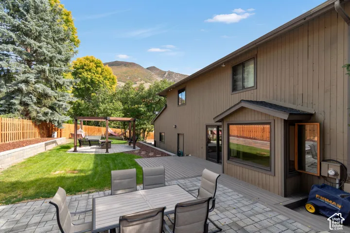 Expansive backyard featuring a paver patio and a separate elevated deck