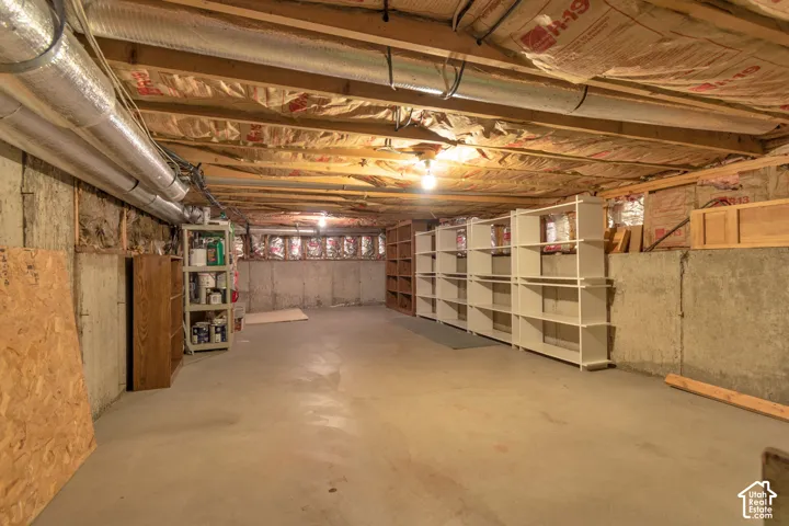 Unfinished basement with concrete flooring and exposed joists