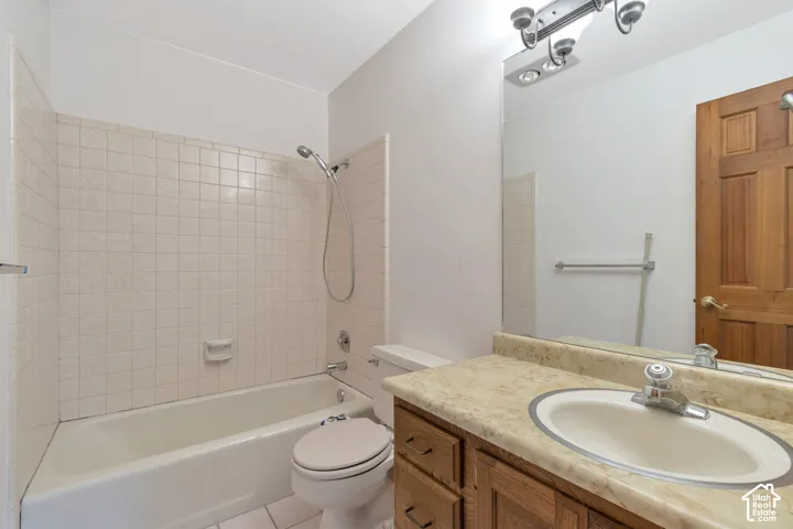 Bathroom featuring a vanity with wood-finish cabinetry, a single basin sink, and a light-colored countertop