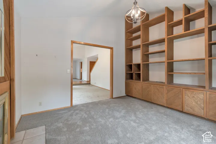 Spacious room featuring custom wood-frame built-in shelving with lower cabinetry, polished concrete flooring, and abundant natural light