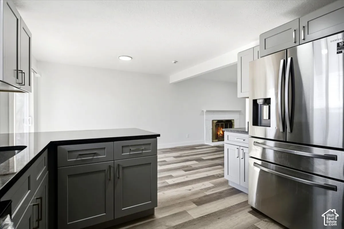 Modern kitchen featuring dark cabinetry, dark countertops, and stainless steel appliances