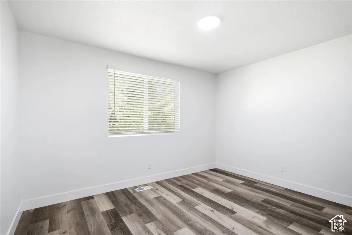 Wood-finish flooring, recessed ceiling light, and a window with blinds