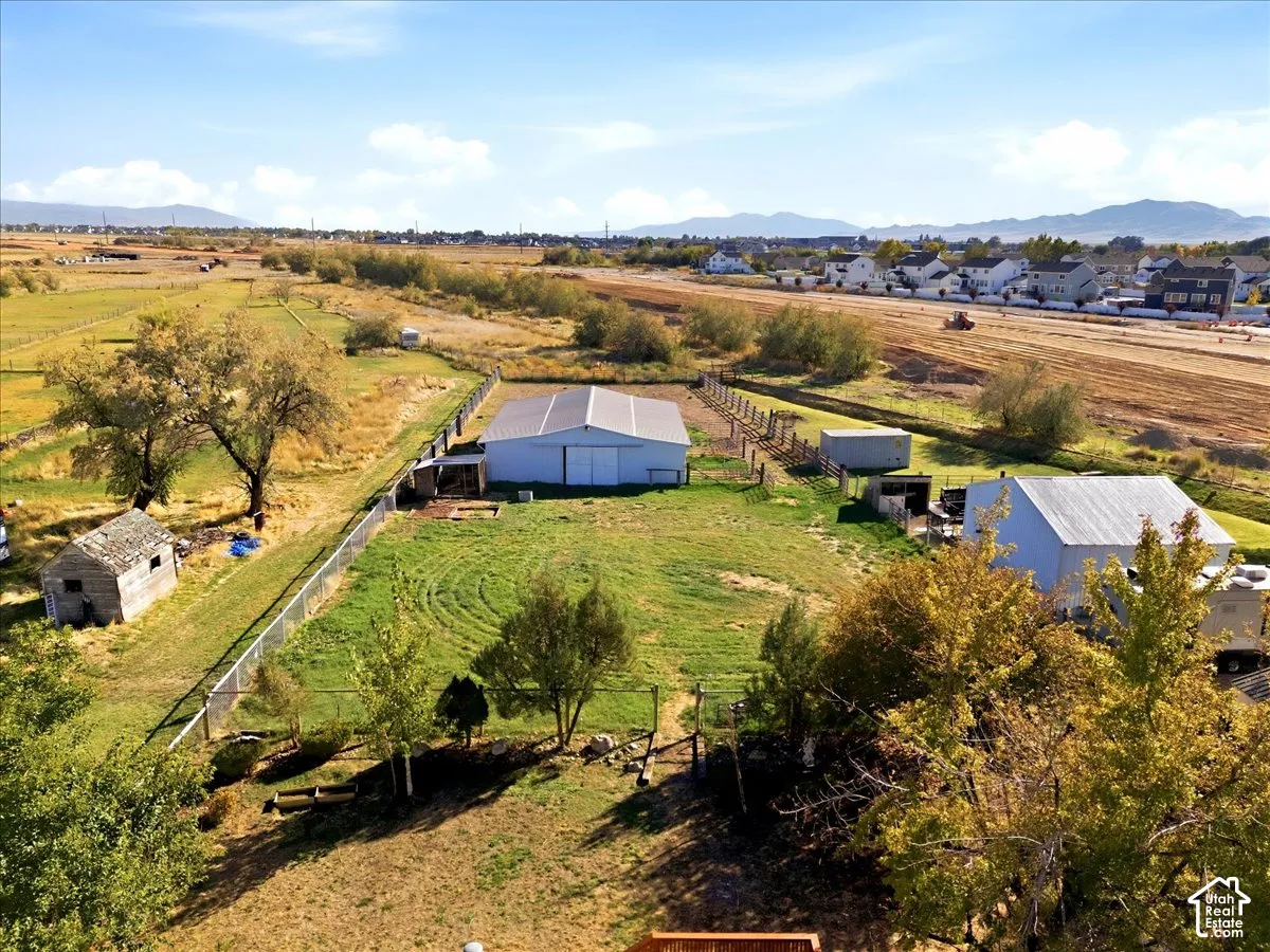 Expansive rural property featuring multiple outbuildings, fenced areas, and mature trees