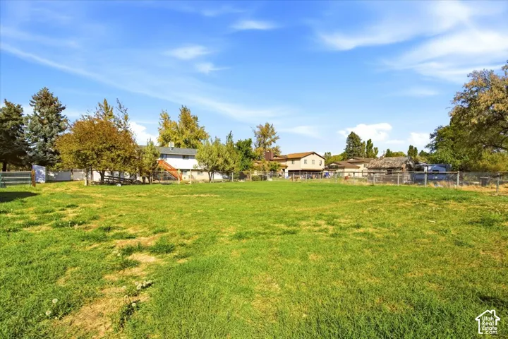 Expansive green space with perimeter fencing and mature trees