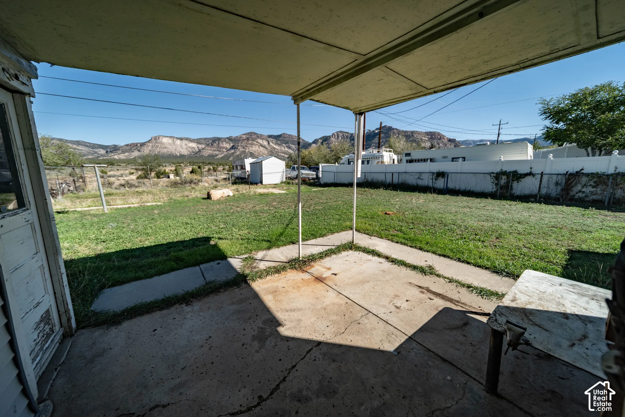 Covered concrete patio opening to a grass lawn