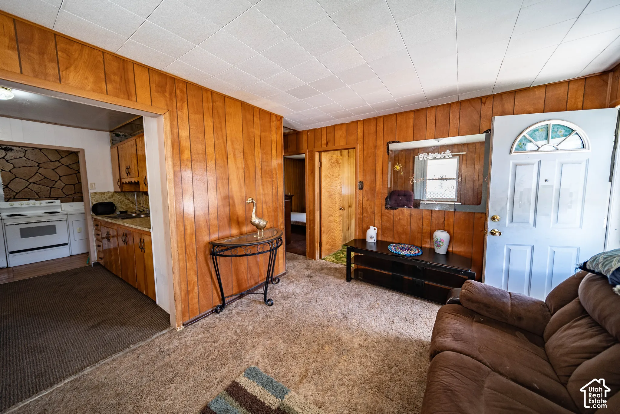 Wood-paneled interior walls, white paneled ceiling, and a doorway with a decorative transom window