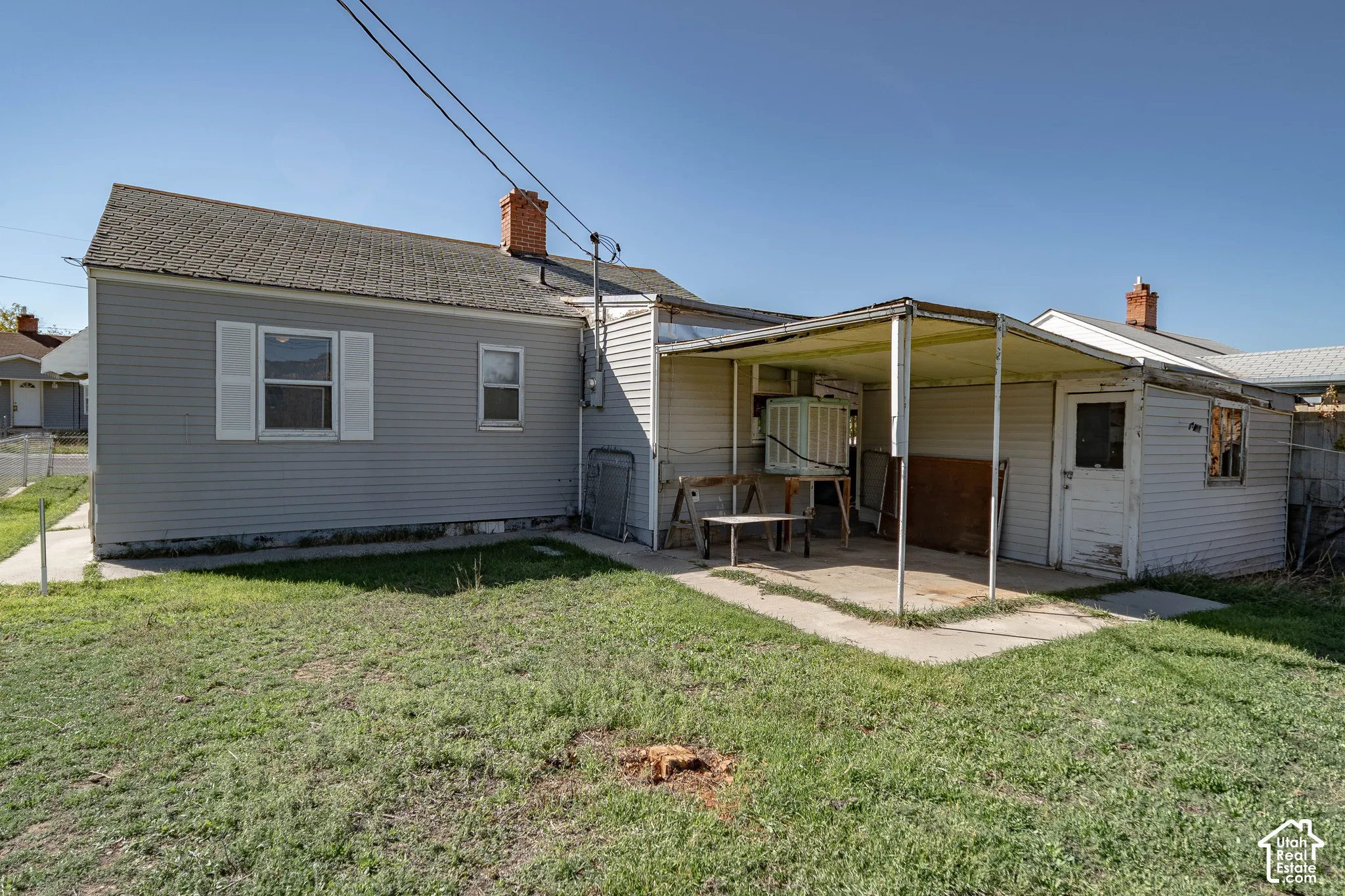 Siding exterior with architectural shingles, covered patio, and concrete walkway