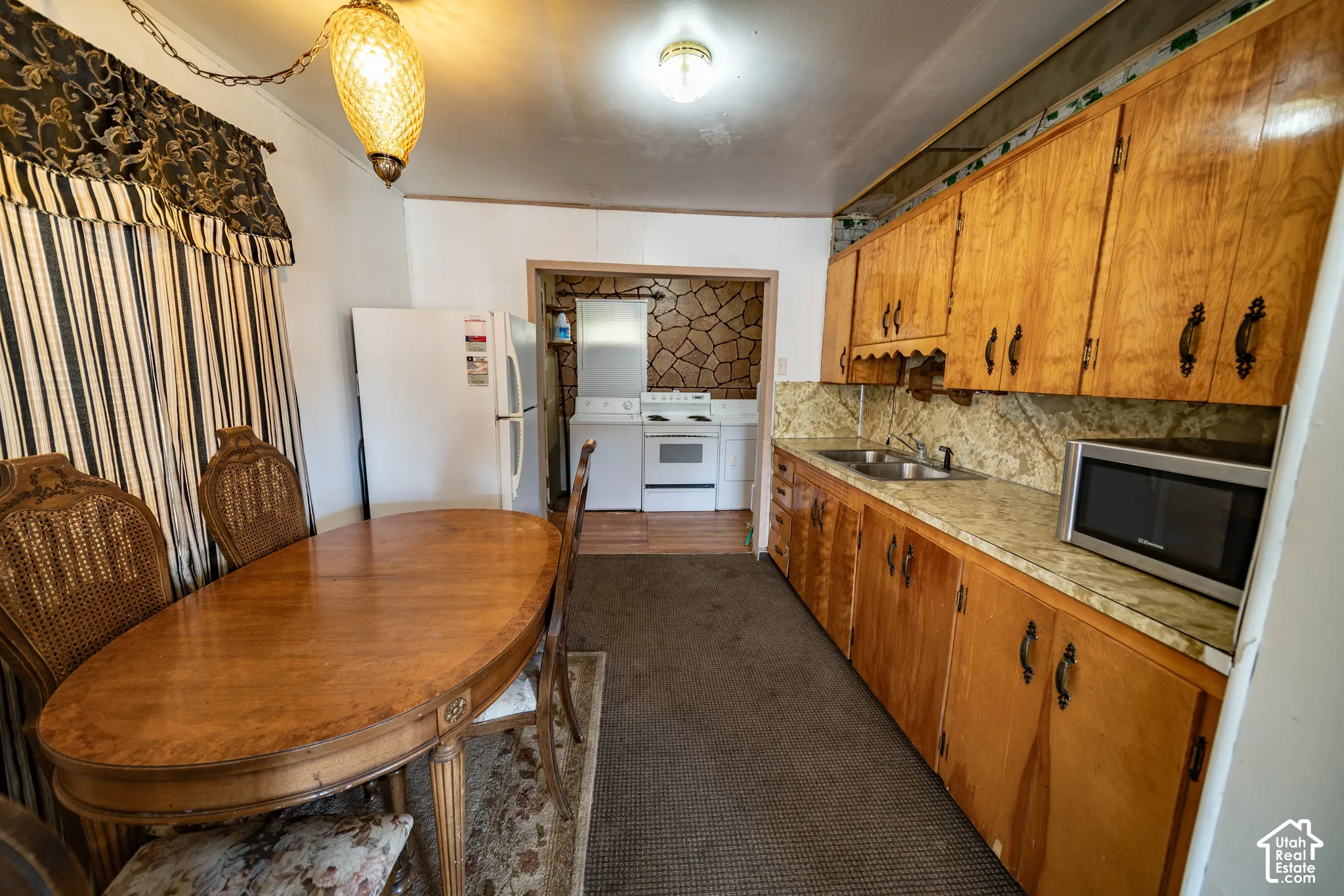 Kitchen area featuring wood-finish cabinetry, a double basin sink, and a laminate countertop