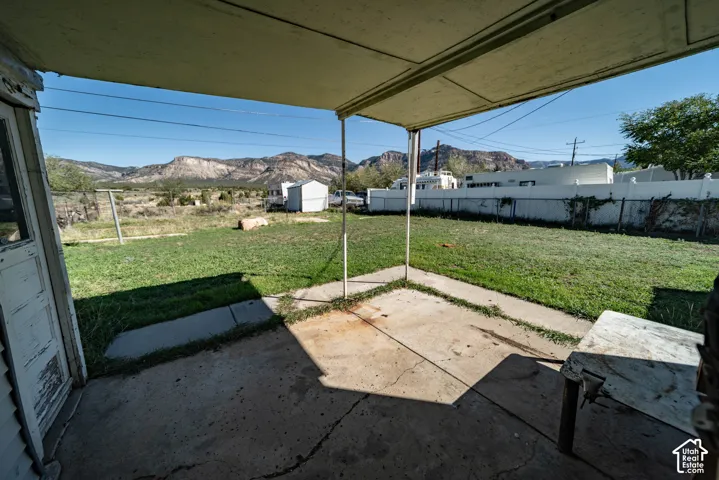Covered concrete patio opening to a grass lawn