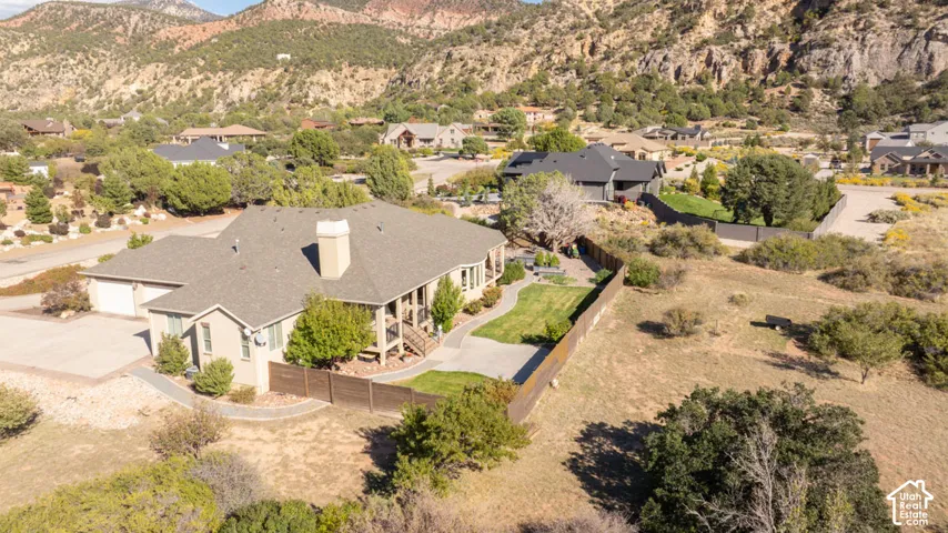 Expansive property featuring a neutral-toned stucco exterior, attached garage, covered porch, and a manicured lawn area