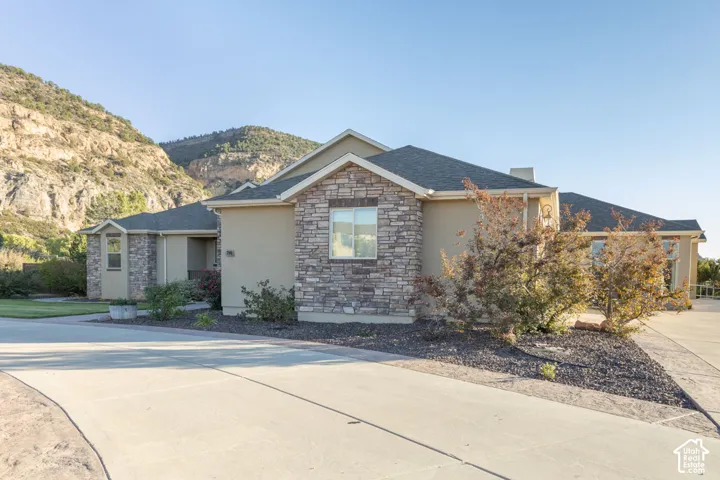 Stucco and stone exterior with dark shingles