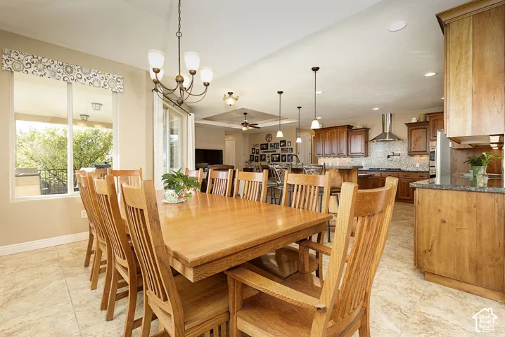 Expansive dining area featuring tiled flooring, a large window, a sliding glass door, and a chandelier