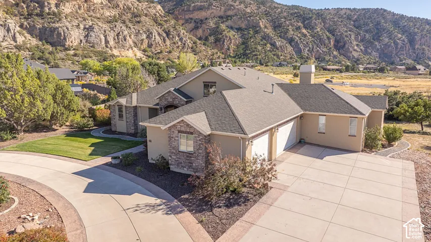 Stucco exterior with stone accents, an attached two-car garage, and a concrete driveway