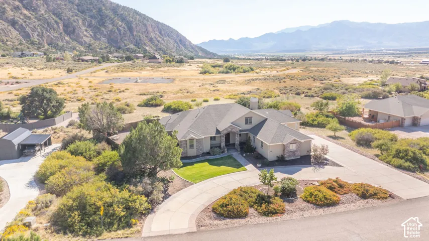 Expansive property with a paved circular driveway, manicured lawn, and a separate covered parking structure