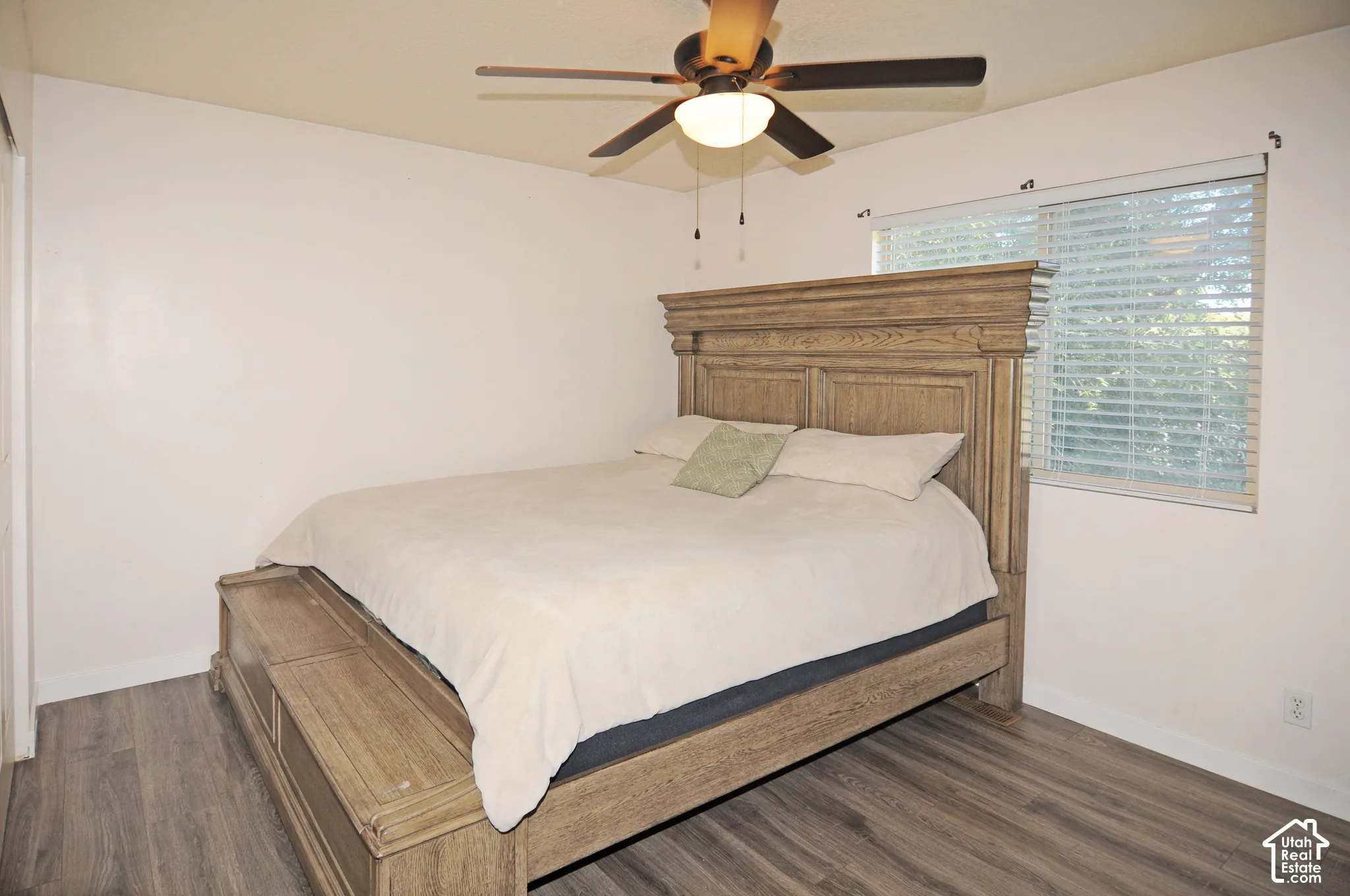 Wood-finish flooring, ceiling fan with integrated lighting, and a window with blinds