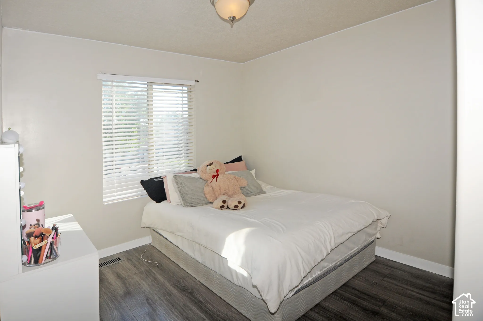 Light-toned walls with a window featuring horizontal blinds