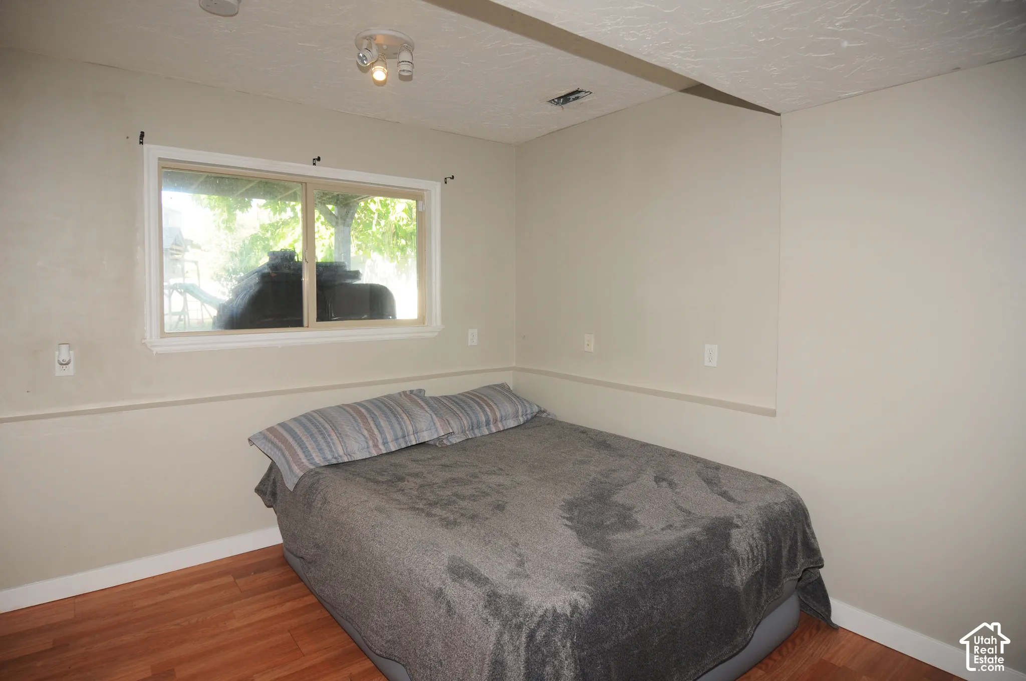Window with white trim and natural light, recessed lighting fixture, light-colored walls, wood-finish flooring