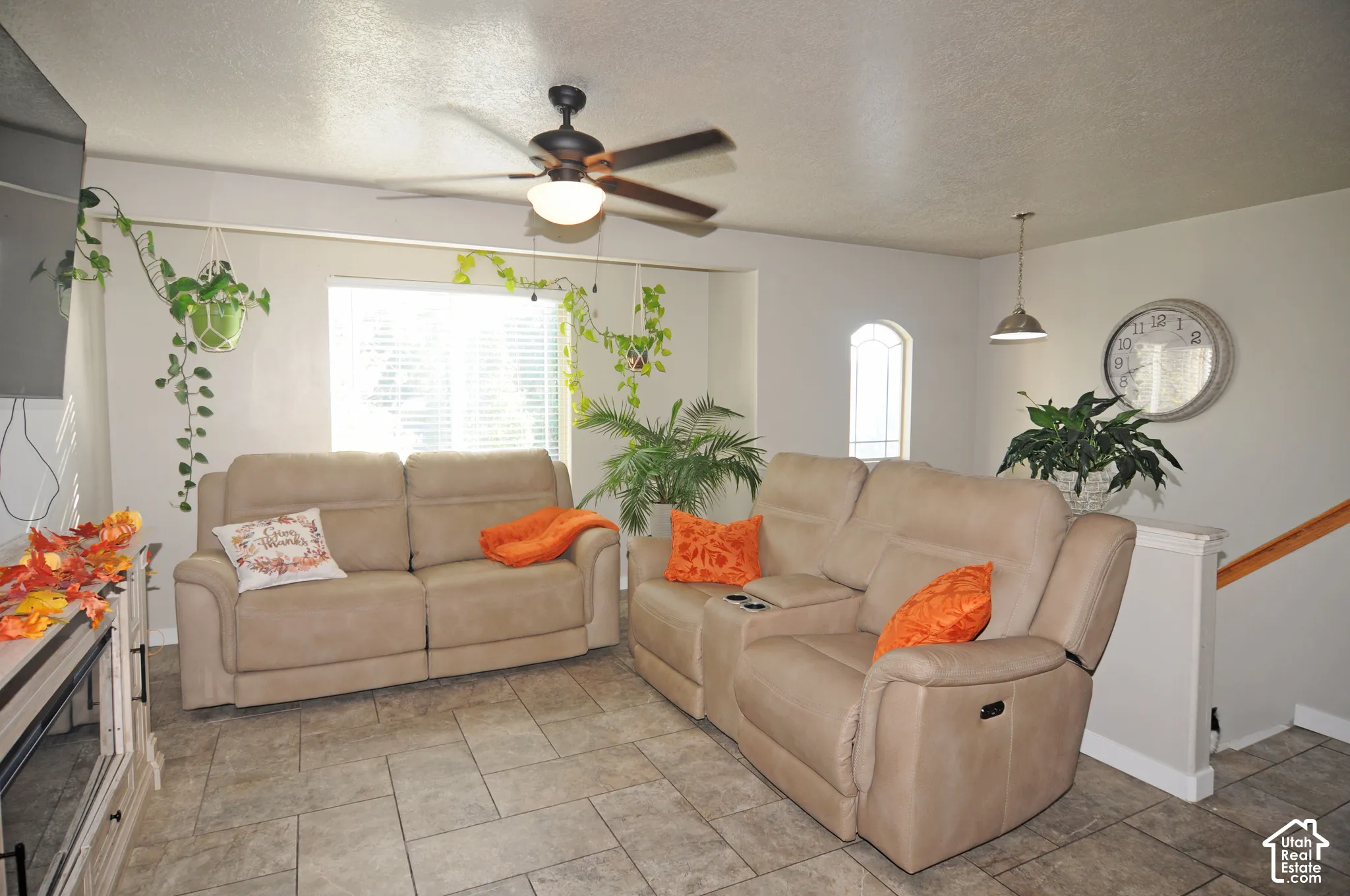 Recessed lighting, ceiling fan with integrated light, tiled flooring, arched window accent, and a built-in media console
