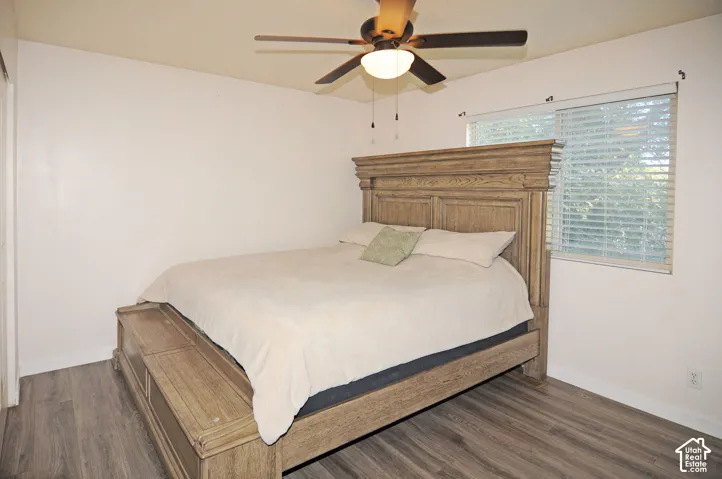 Wood-finish flooring, ceiling fan with integrated lighting, and a window with blinds