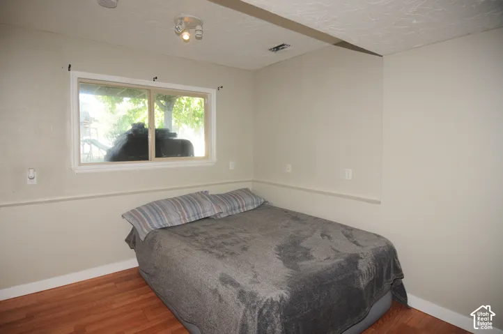 Window with white trim and natural light, recessed lighting fixture, light-colored walls, wood-finish flooring