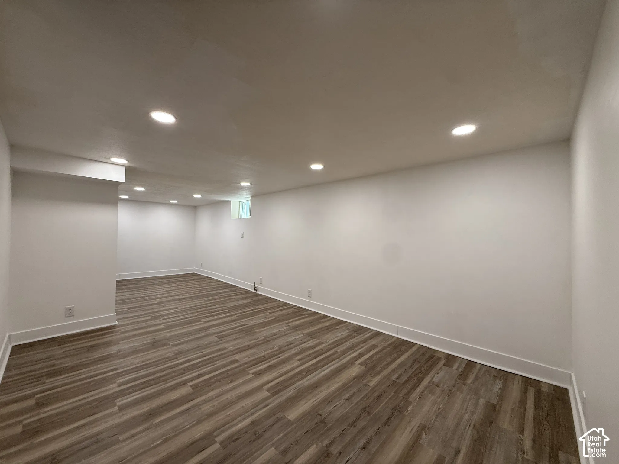 Open-concept interior featuring wood-finish flooring, recessed lighting, and a neutral color palette