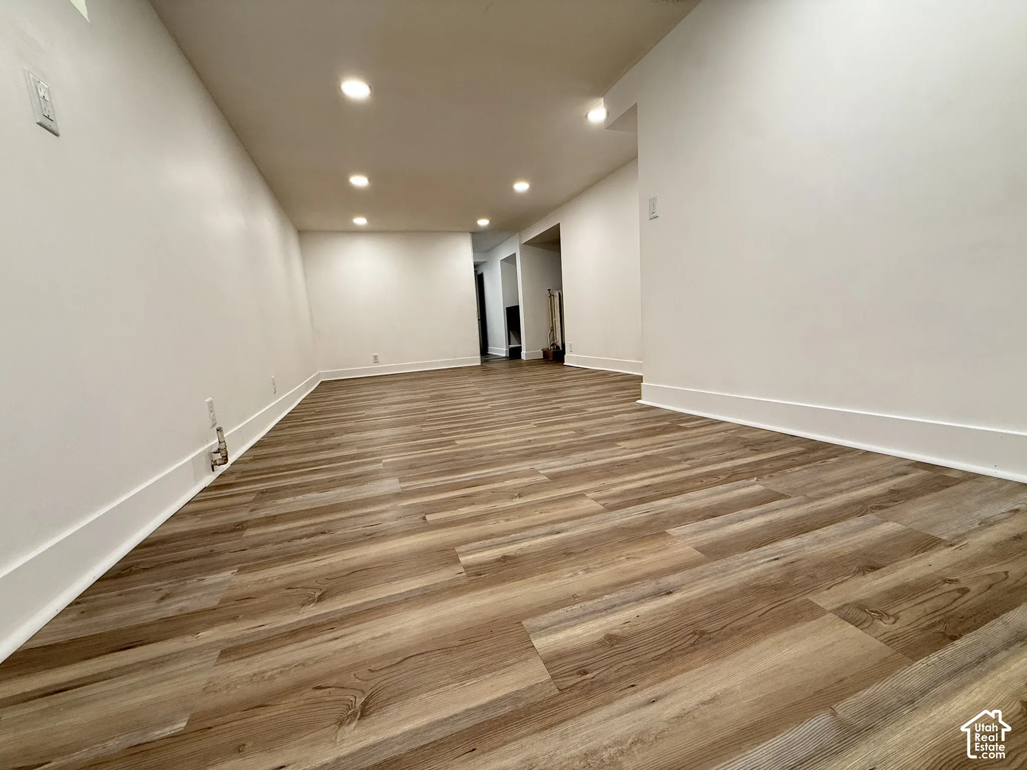 Interior space featuring wood-finish flooring, white walls, and recessed ceiling lighting