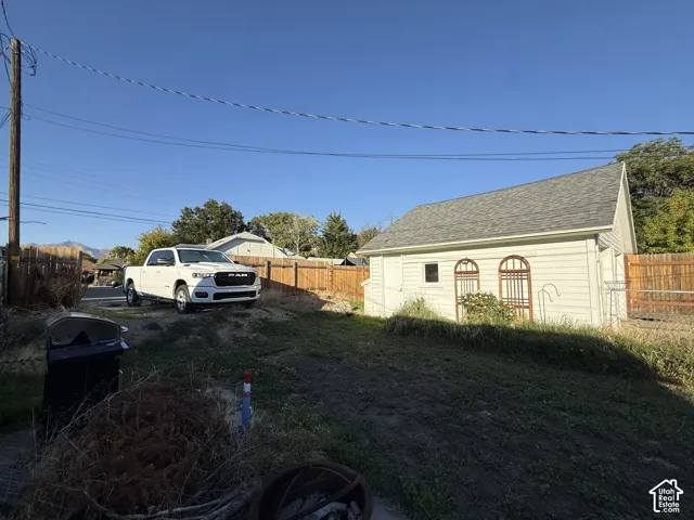 Detached garage structure with siding and a shingled roof