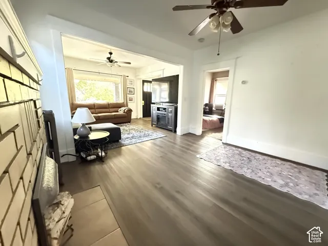 Wood-finish flooring throughout, recessed archway, and ceiling fan