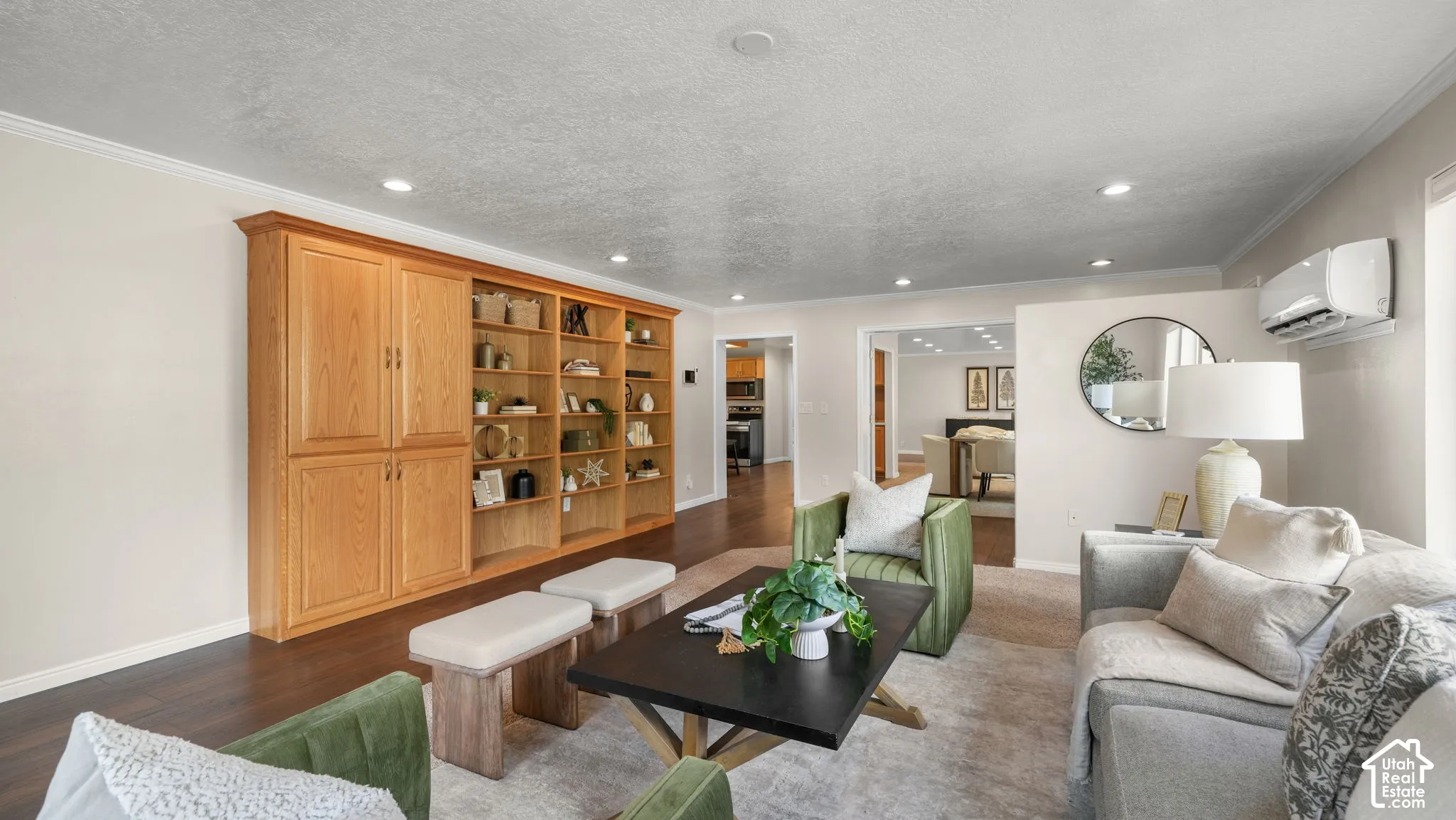 Expansive custom built-in cabinetry with integrated shelving, recessed lighting, wood-finish flooring, and crown molding