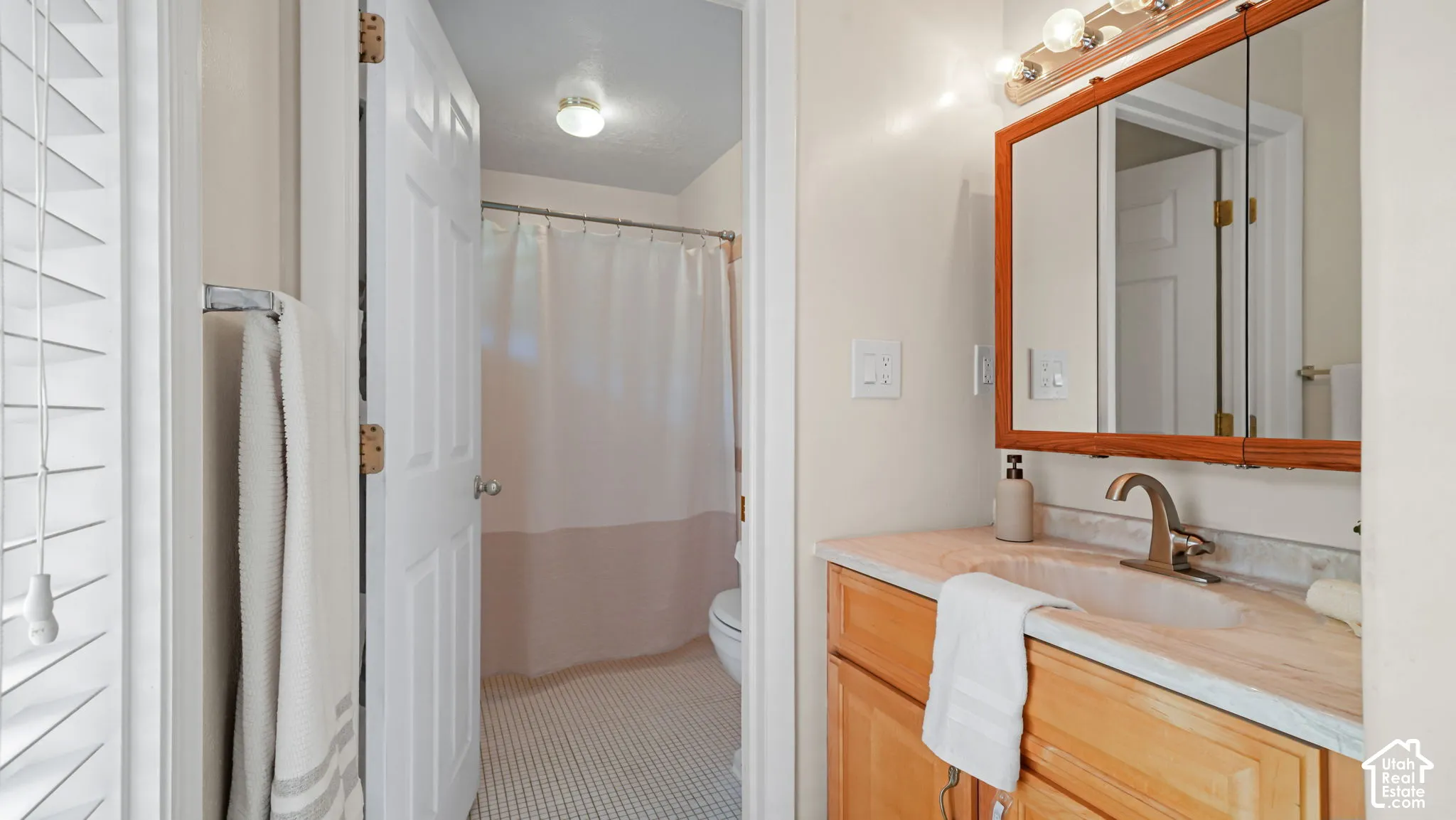 Wood-finish vanity with an integrated sink and light-toned countertop