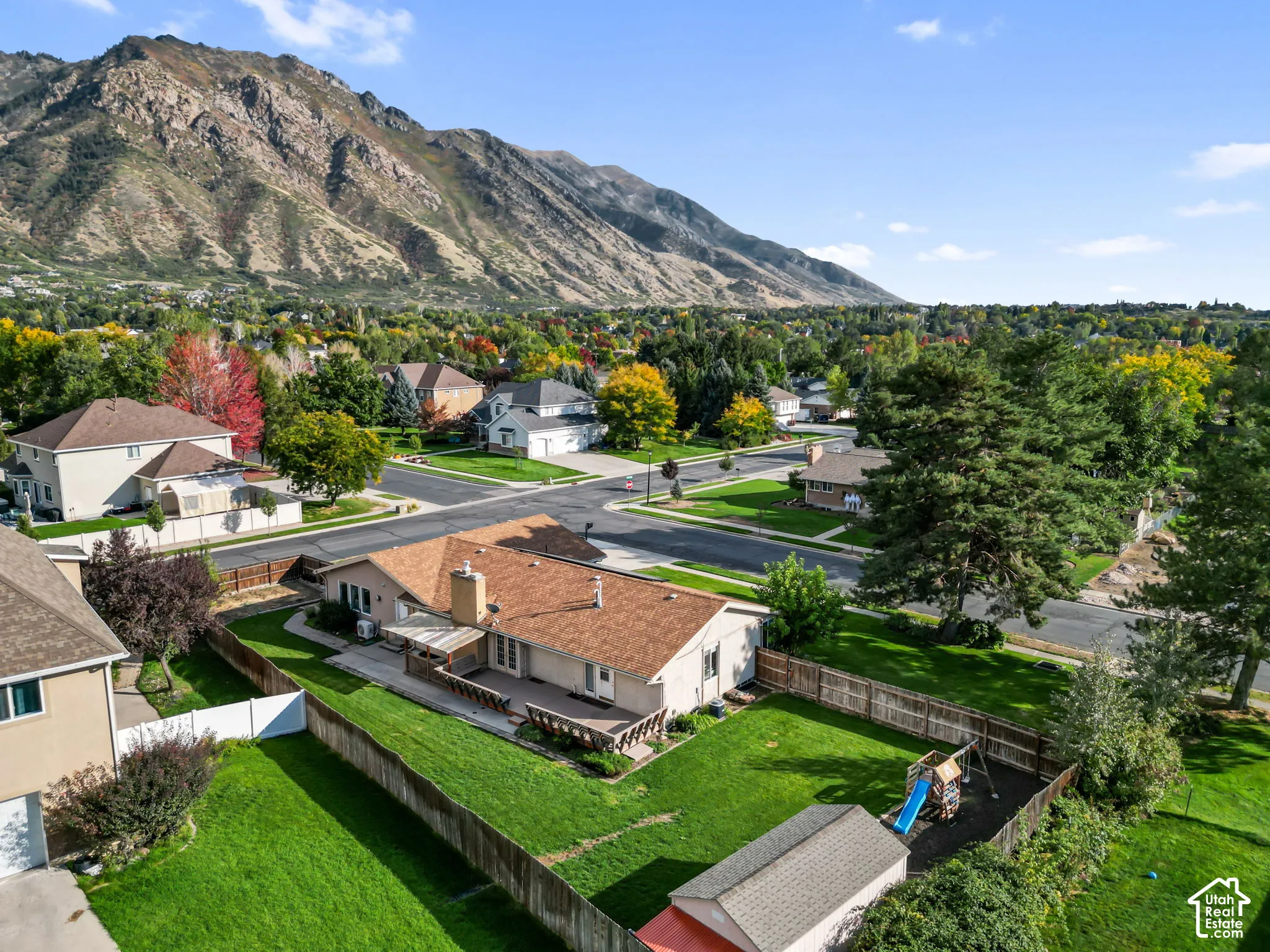 Rambler backyard with a manicured lawn, a built-in deck, and a wood privacy fence