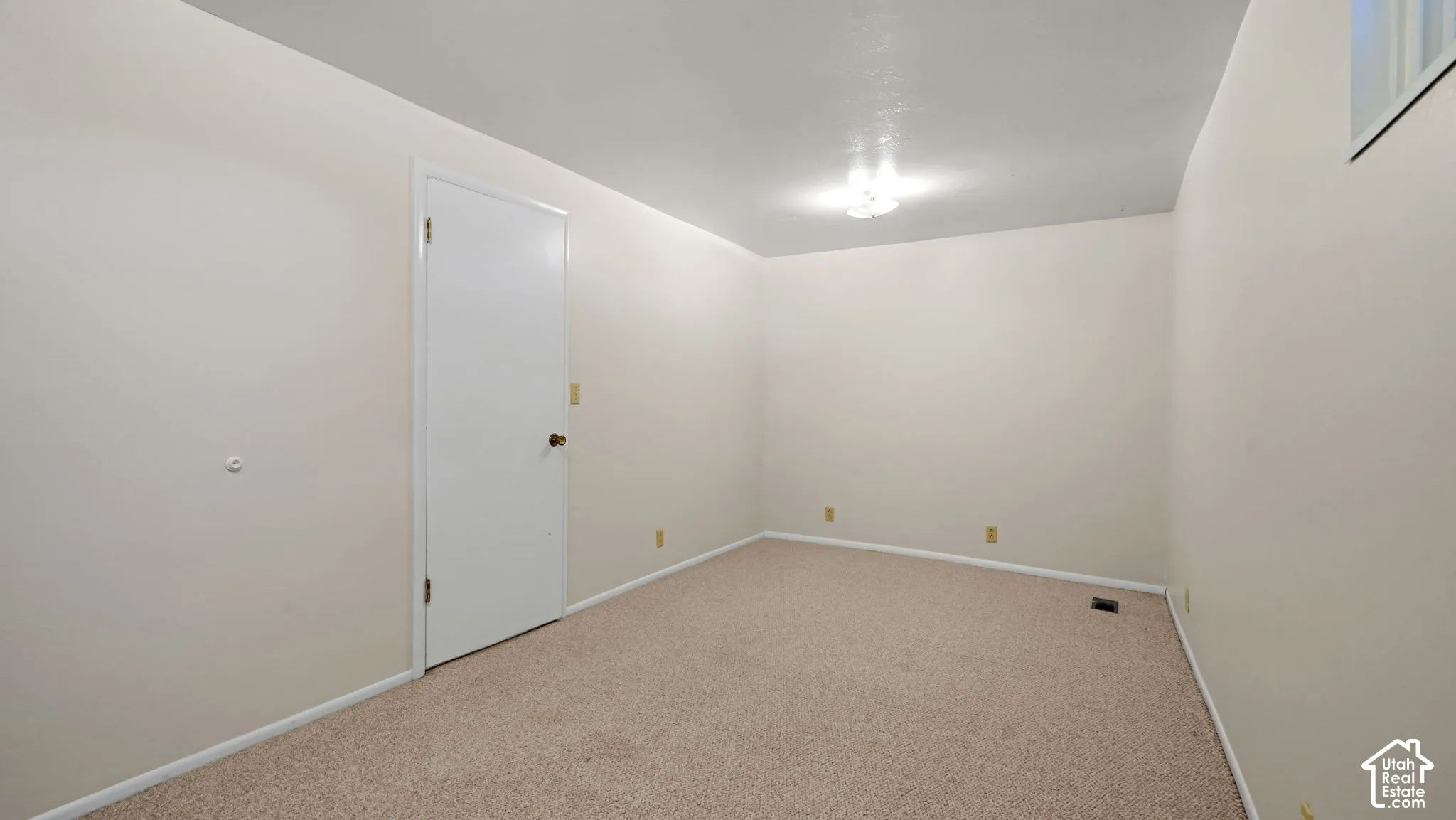 Neutral wall finishes, recessed window, and light-toned carpet flooring