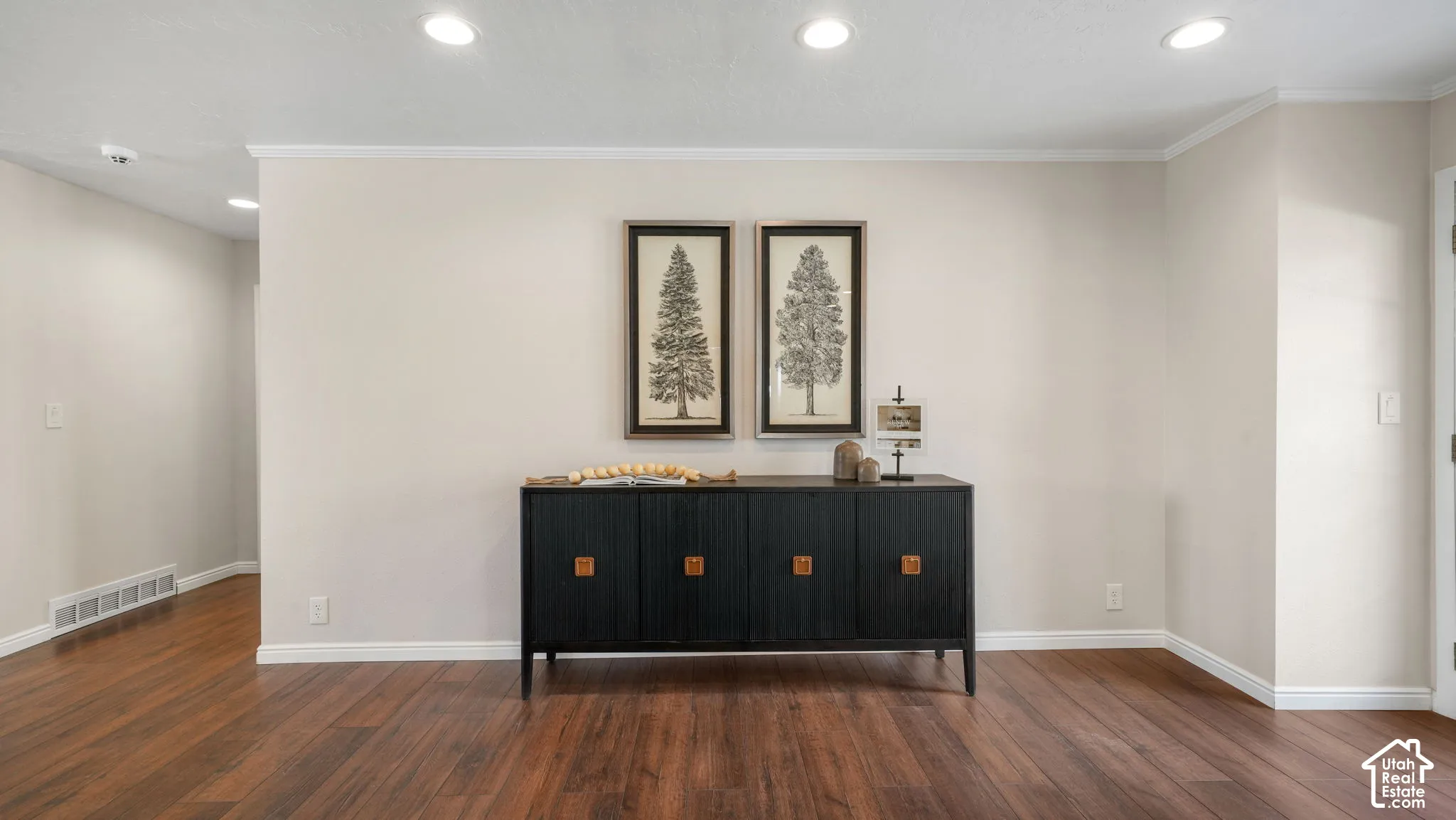 Wood-finish flooring, recessed lighting, crown molding, and neutral wall tones