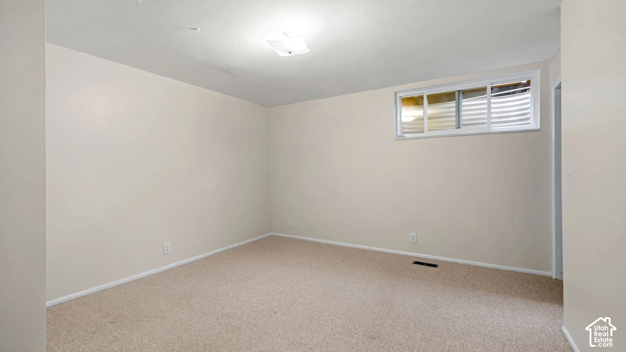 Neutral wall tones, recessed window, and light carpeting create a versatile interior