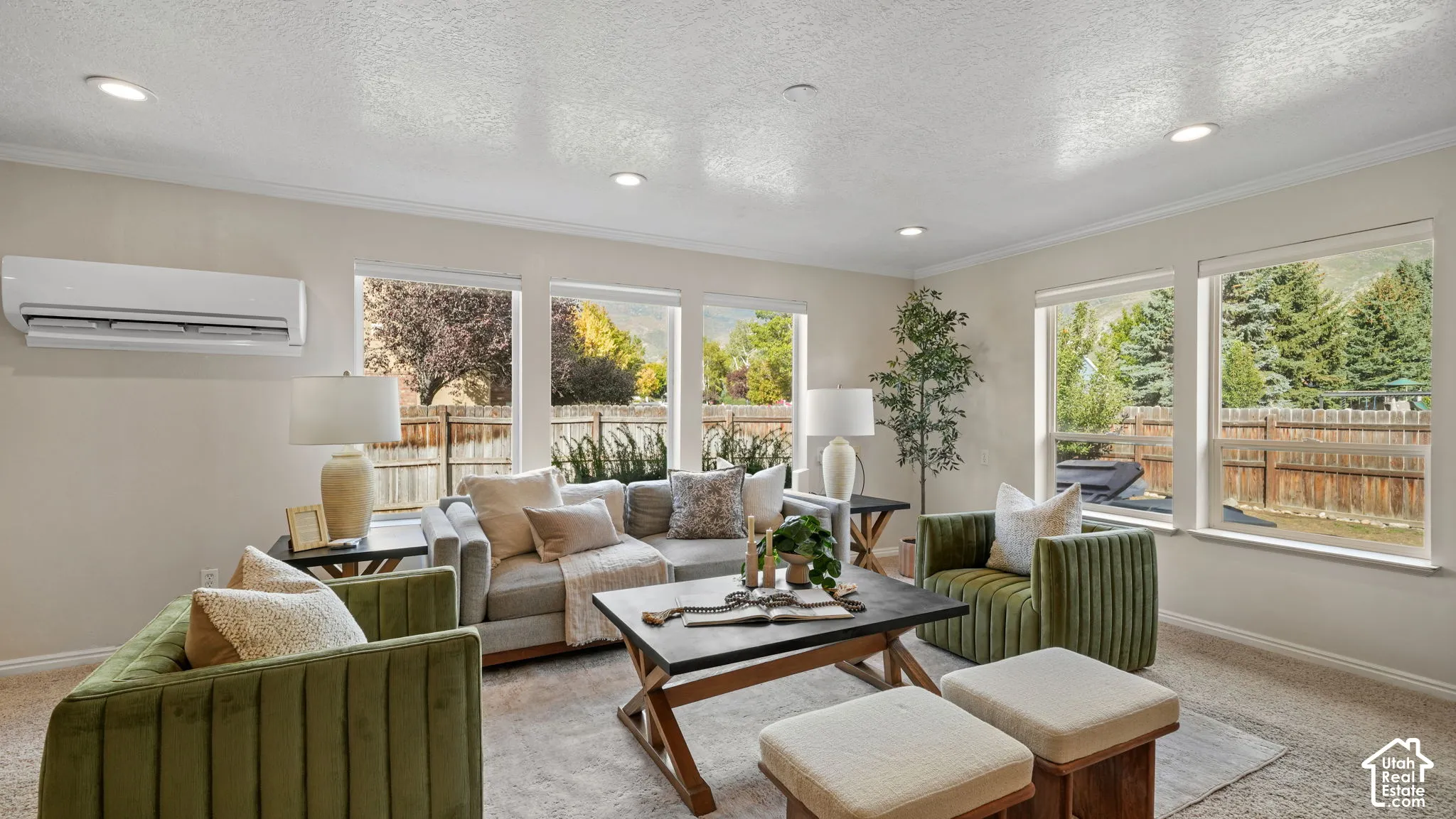 Recessed lighting and a wall-mounted climate control unit complement multiple windows offering abundant natural light