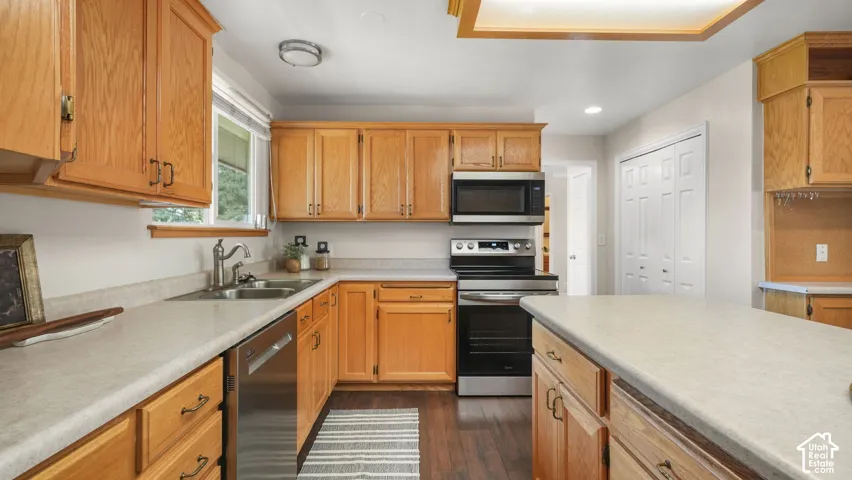 Wood-finish cabinetry paired with light-toned countertops and stainless steel appliances