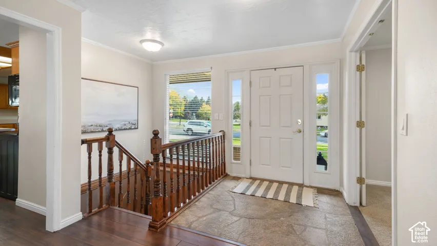 Entryway with a solid panel door, two sidelight windows, and stone-finish flooring