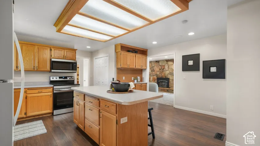 Kitchen featuring wood-finish flooring, recessed lighting, and a center island with countertop seating