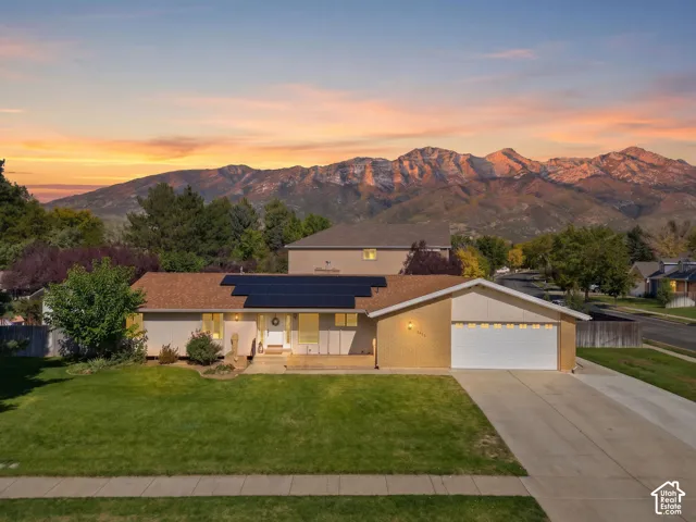 Ranch-style exterior with a shingle roof and solar panels