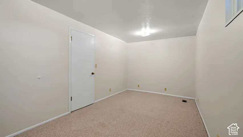 Neutral wall finishes, recessed window, and light-toned carpet flooring