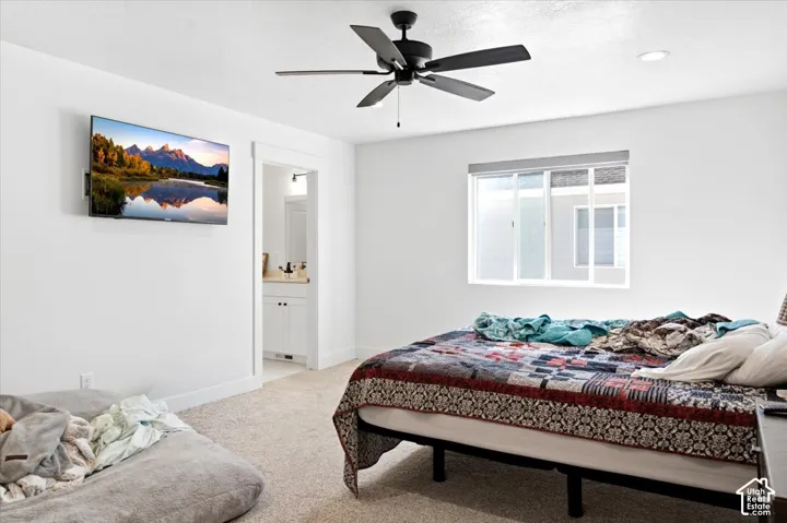 Recessed lighting and ceiling fan complement the neutral wall finishes and carpeted flooring