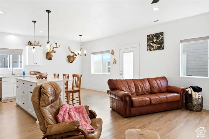 Open-concept living area featuring wood-finish flooring, white walls, and recessed lighting