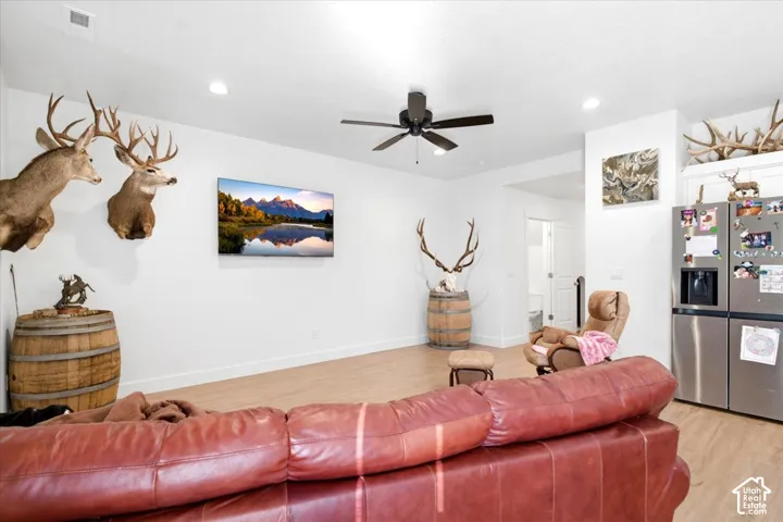 Recessed lighting, wood-finish flooring, ceiling fan, white baseboards, and stainless steel appliances