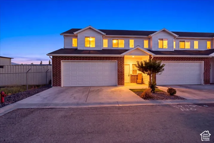 Red brick and white siding exterior with two garage doors and concrete driveways