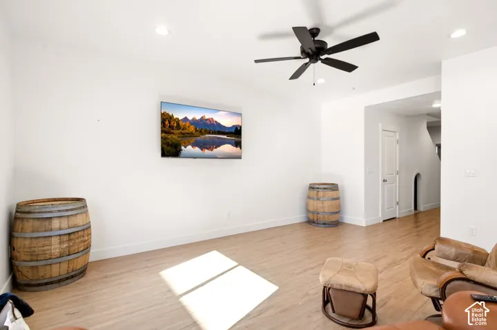 Room featuring wood-finish flooring, recessed lighting, and a multi-blade ceiling fan