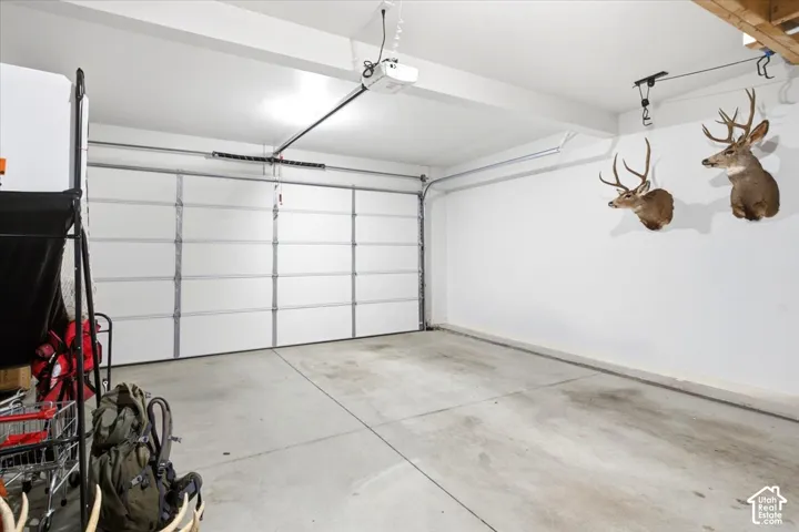 Spacious garage featuring a sectional garage door, concrete flooring, and an automatic garage door opener