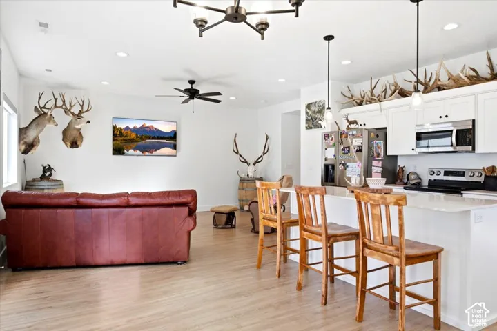 Open-concept living space featuring wood-finish flooring, recessed lighting, and a ceiling fan