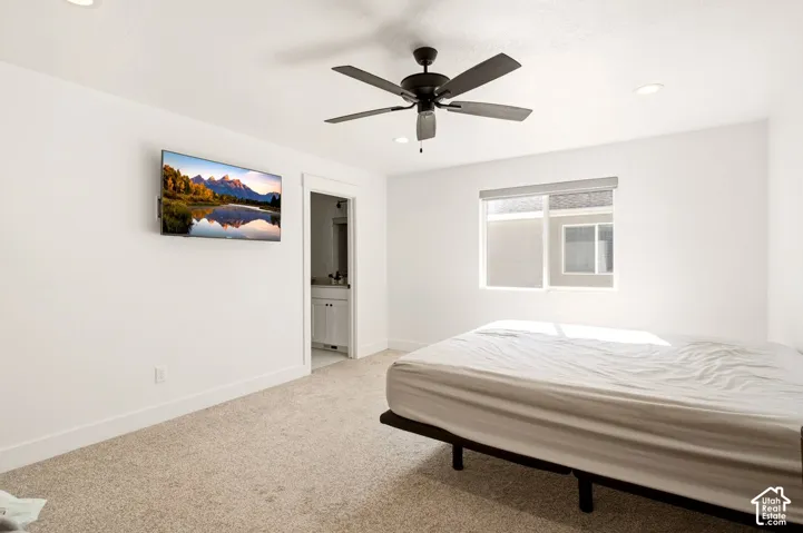 Neutral-toned carpet, recessed lighting, ceiling fan, and sliding window