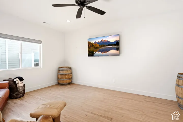Bright interior featuring wood-finish flooring, neutral walls, recessed lighting, and a multi-blade ceiling fan