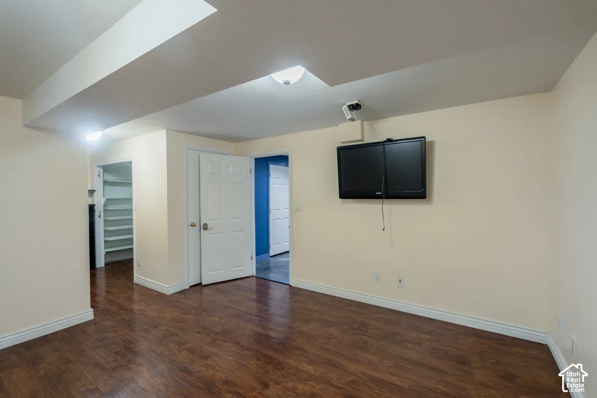 Wood-finish flooring, recessed lighting, and white baseboards